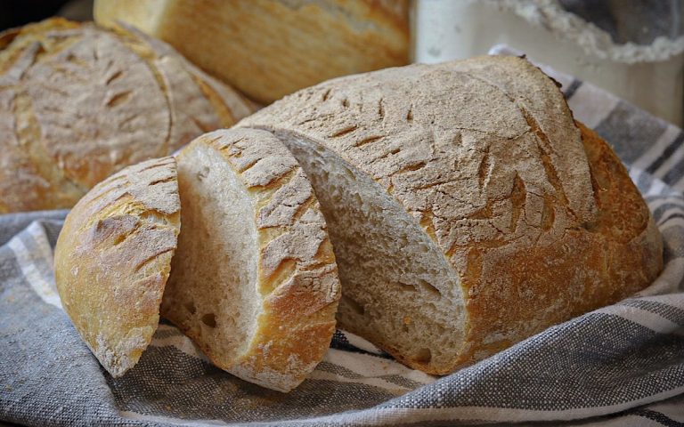 the best sourdough bread sliced on grey and white striped towel