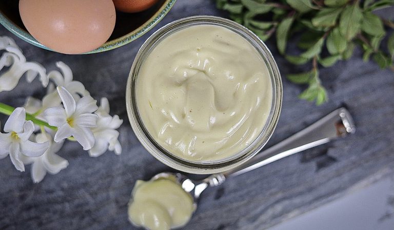 homemade mayonnaise on spoon with flowers and eggs