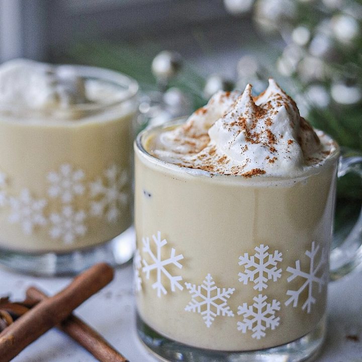 easy step by step homemade eggnog with cinnamon sticks, whipped cream and lights