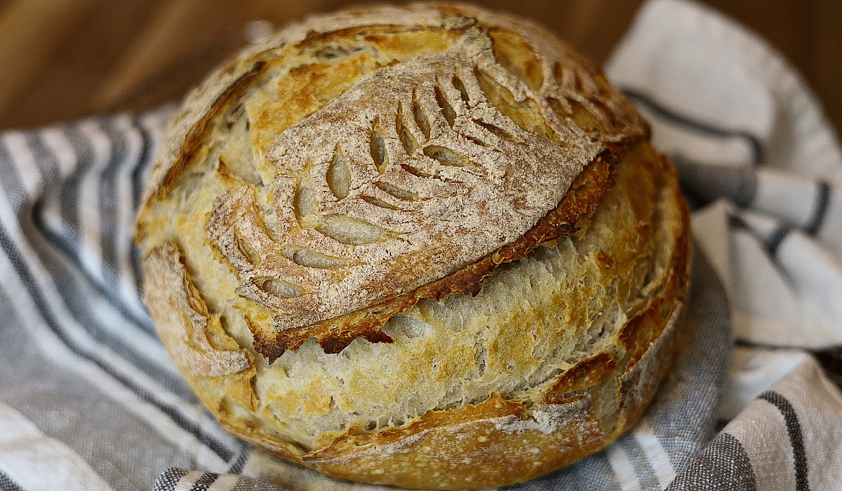 https://simpleisgourmet.com/wp-content/uploads/2021/04/no-knead-sourdough-loaf-from-top-on-towel.jpg