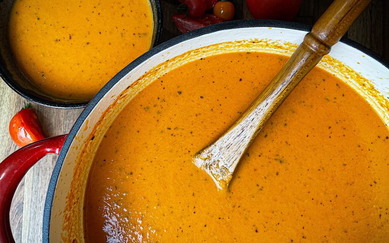 tomato basil soup with wooden spoon