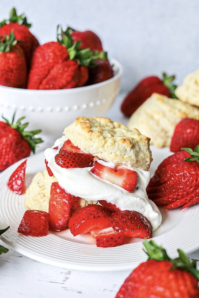Quick Strawberry Shortcake Made with Biscuits on white plate with strawberries