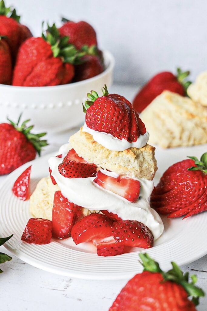 Quick Strawberry Shortcake Made with Biscuits on white plate with strawberries simple is gourmet