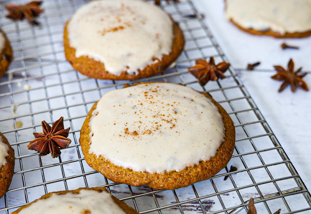 The Best Pumpkin Sourdough Cookies with Maple Frosting with spices on cooling rack simple is gourmet
